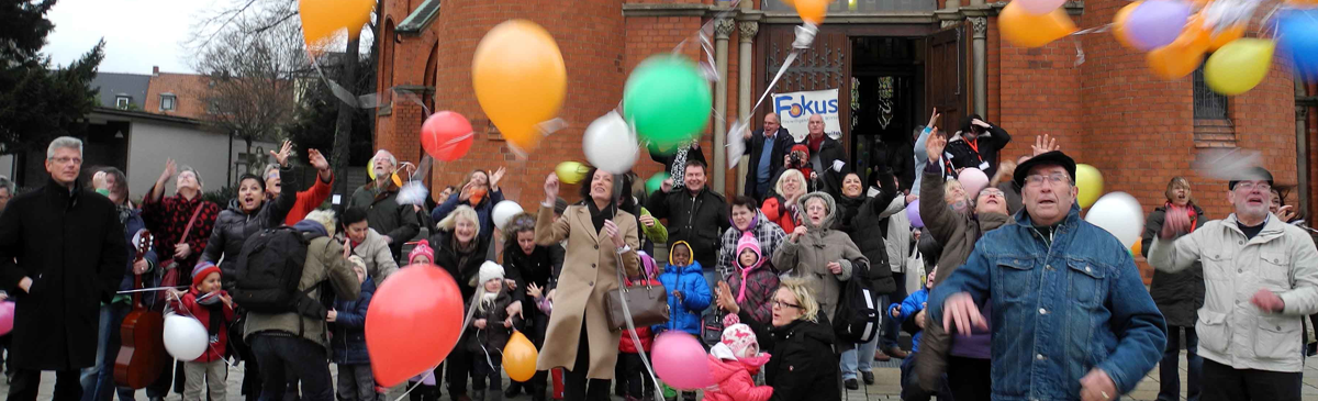 Ehrenamtliche lassen Luftballons vor der Marienkirche steigen